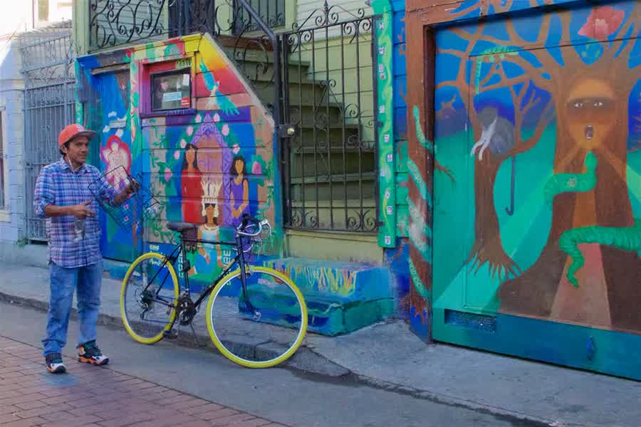 Mann mit Fahrrad vor Murals in der Balmy Alley