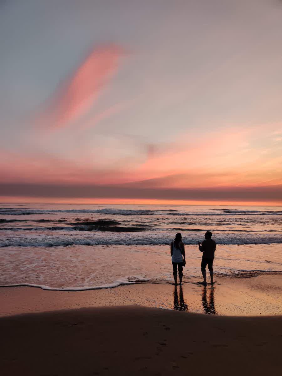 Zwei Menschen am Ocean Beach bei Sonnenuntergang
