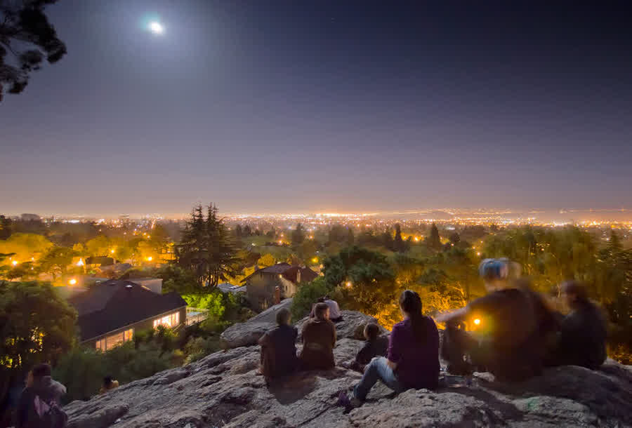 Menschen sitzen in der Abenddämmerung auf dem Indian Rock